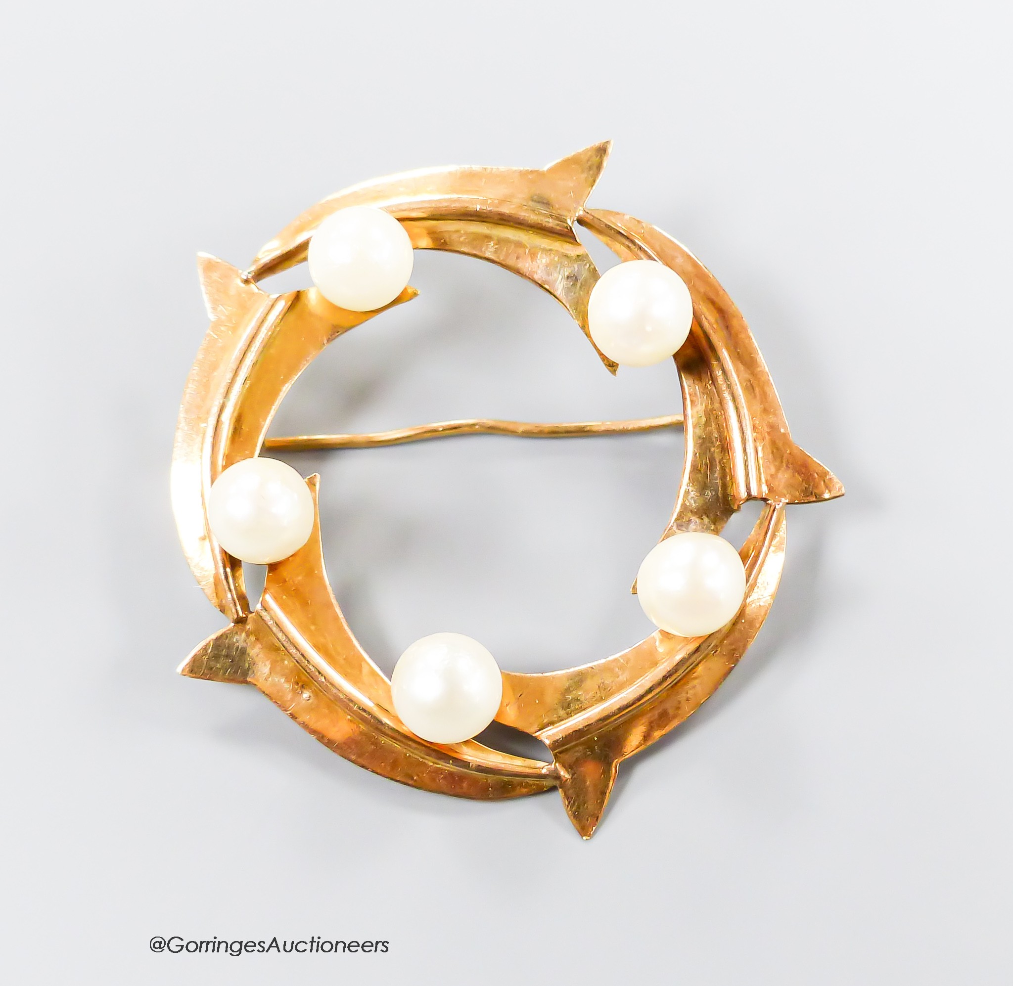 An 18k yellow metal five stone cultured pearl set openwork circular brooch, 33mm, gross 4.4 grams.